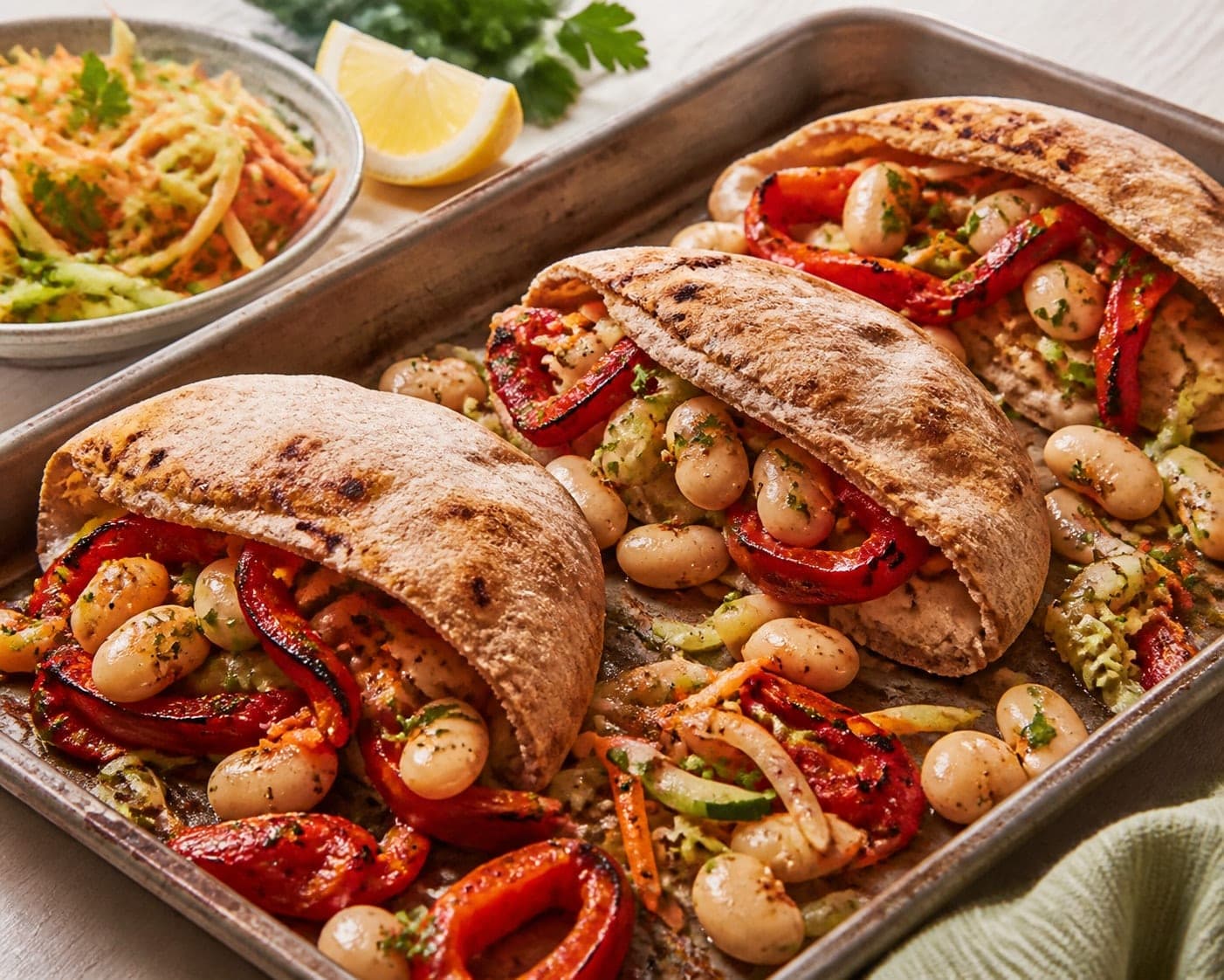 Roasted Pepper Butter Bean Pitta Breads with Lemon Parsley Slaw plated and ready to serve.